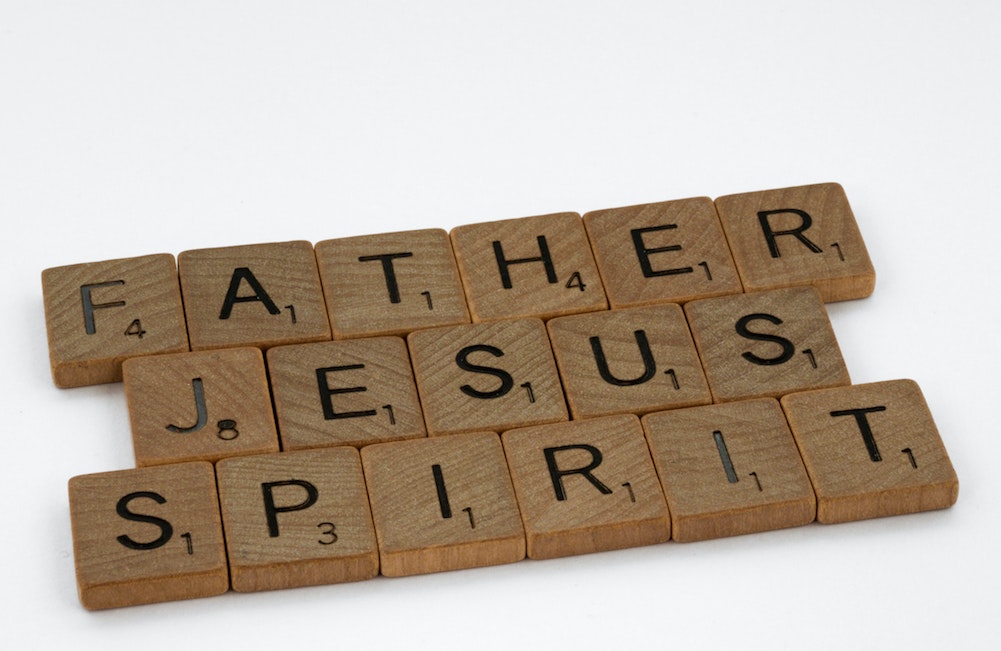 Father, Jesus and Spirit spelled out in Scrabble tiles