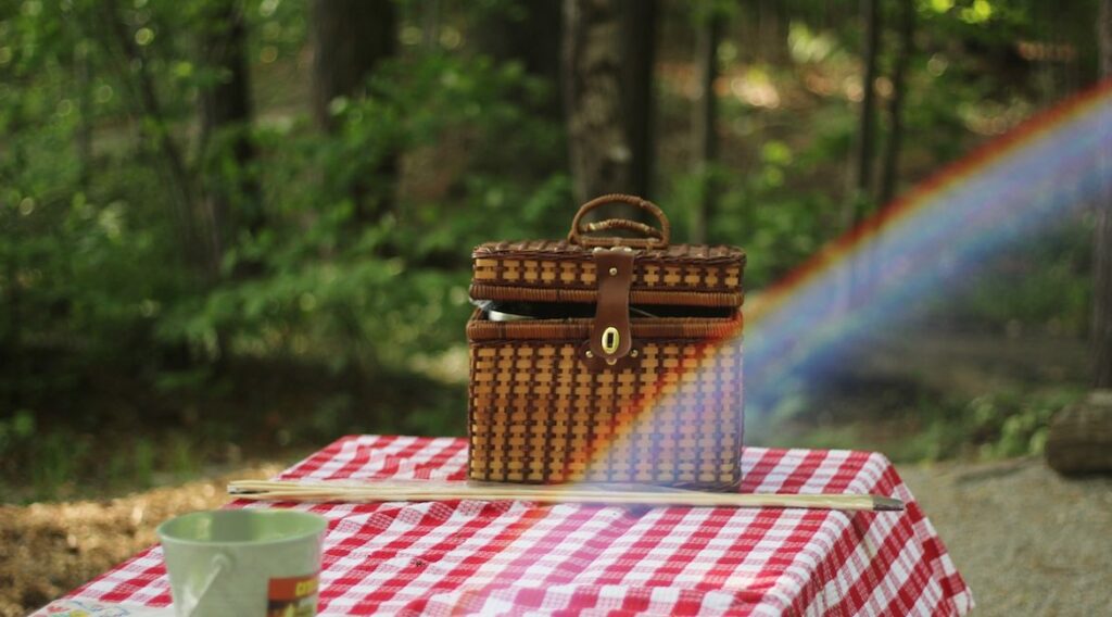 Picnic Basket on Table in Forest with Rainbow