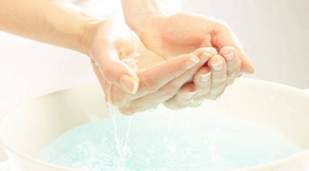 cupped hands holding water to wash face