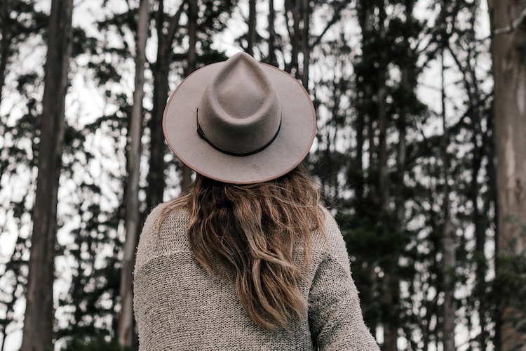 young woman wearing hat alone