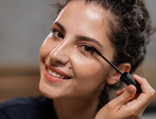beautiful woman applying mascara