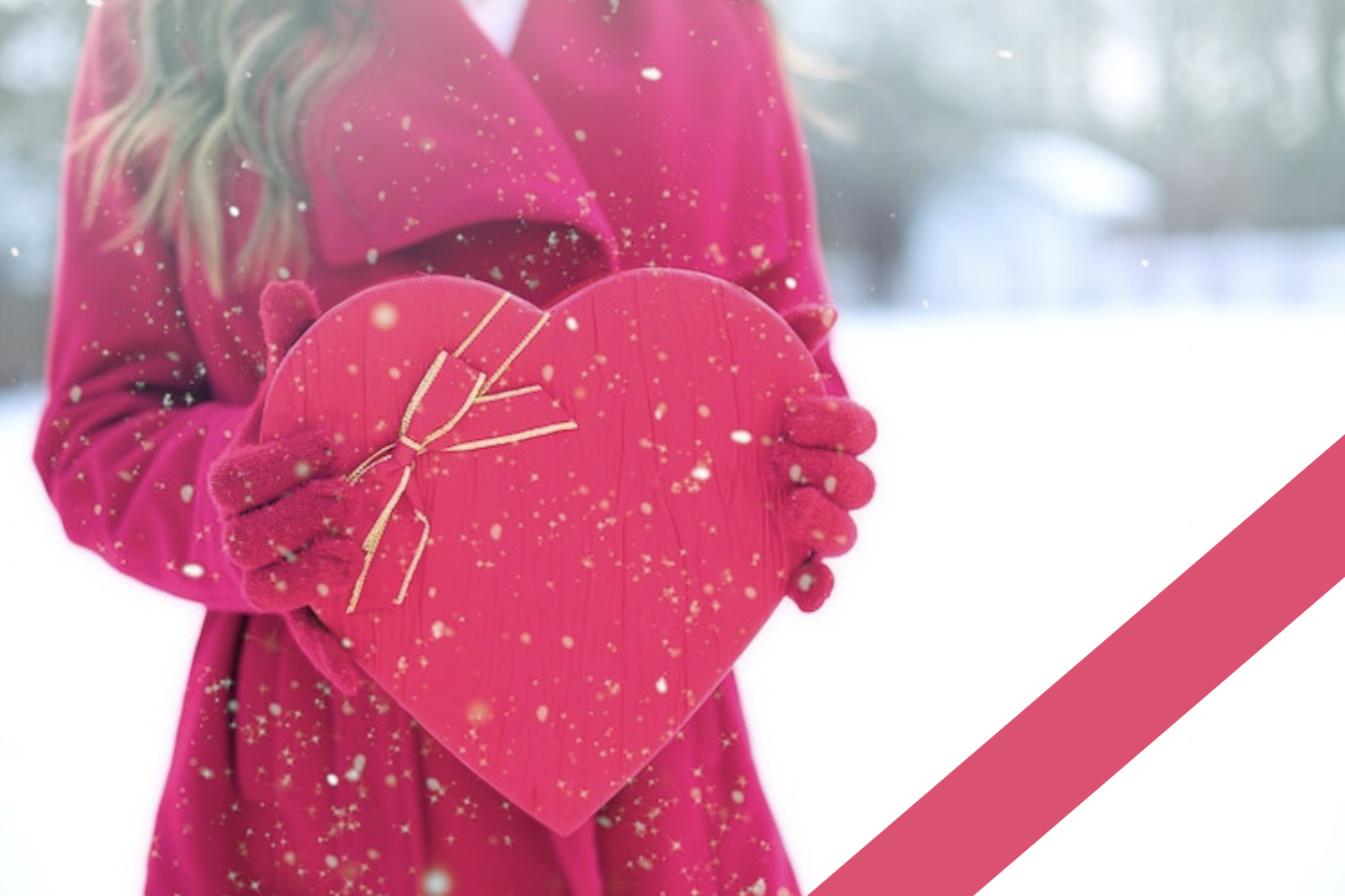 young woman holding a heart shaped box of chocolates in the snow
